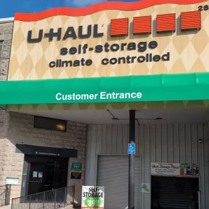Green sign-box awning with eradicated graphics installed above Uhaul Entrance