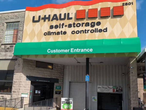 Green sign-box awning with eradicated graphics installed above Uhaul Entrance