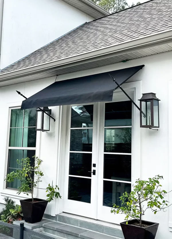 Black fabric venetian awning with decorative spears installed over French doors